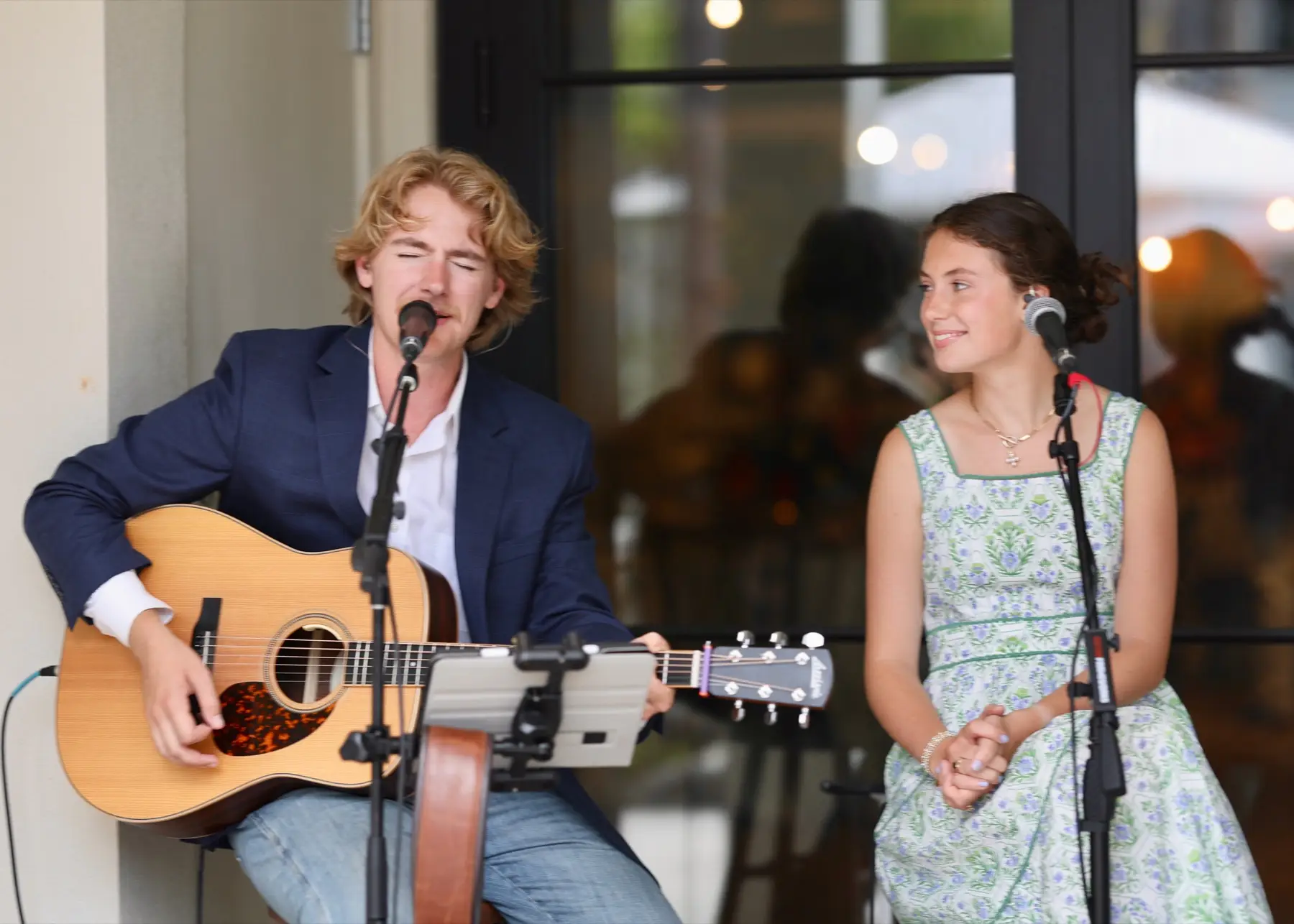 Jake Evans singing and playing acoustic guitar at a live performance